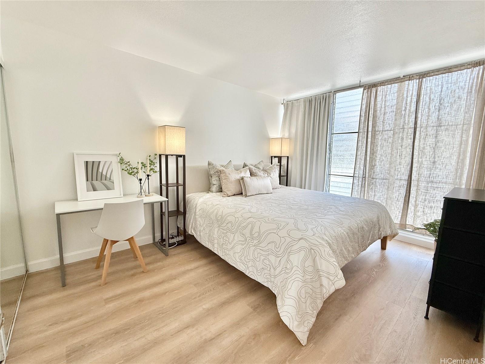 1456 Thurston Avenue, Unit A204 Honolulu, HI 96822 - Photo 6 of 12 a bedroom with a bed a table and chair