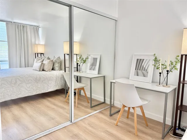 a bedroom with a bed a table and painting on the wall