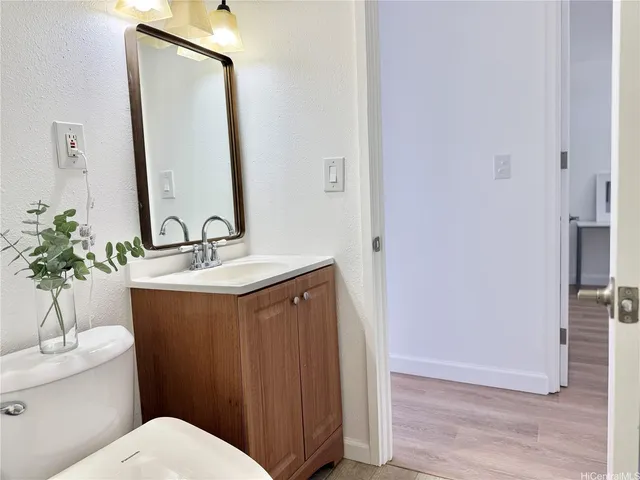 a bathroom with a sink vanity mirror and toilet