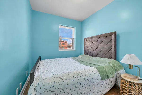 a bedroom with a bed and a lamp on dresser