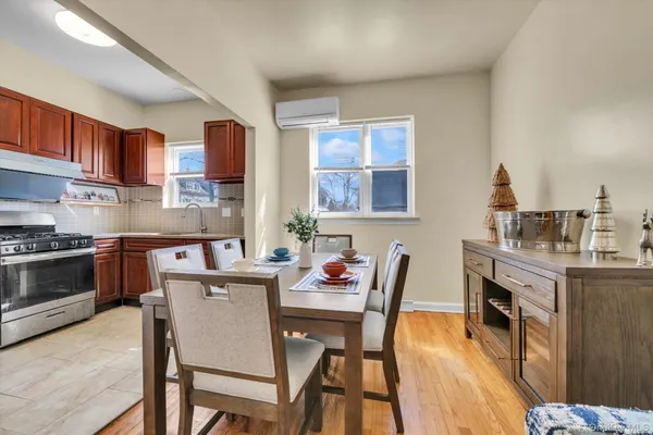 a kitchen with stainless steel appliances granite countertop a stove a sink dishwasher a dining table and chair with wooden floor