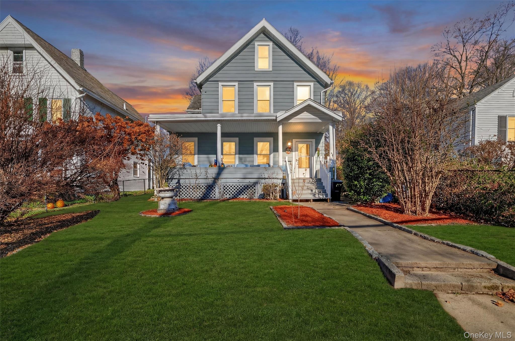 View of front of home featuring covered porch and a yard
