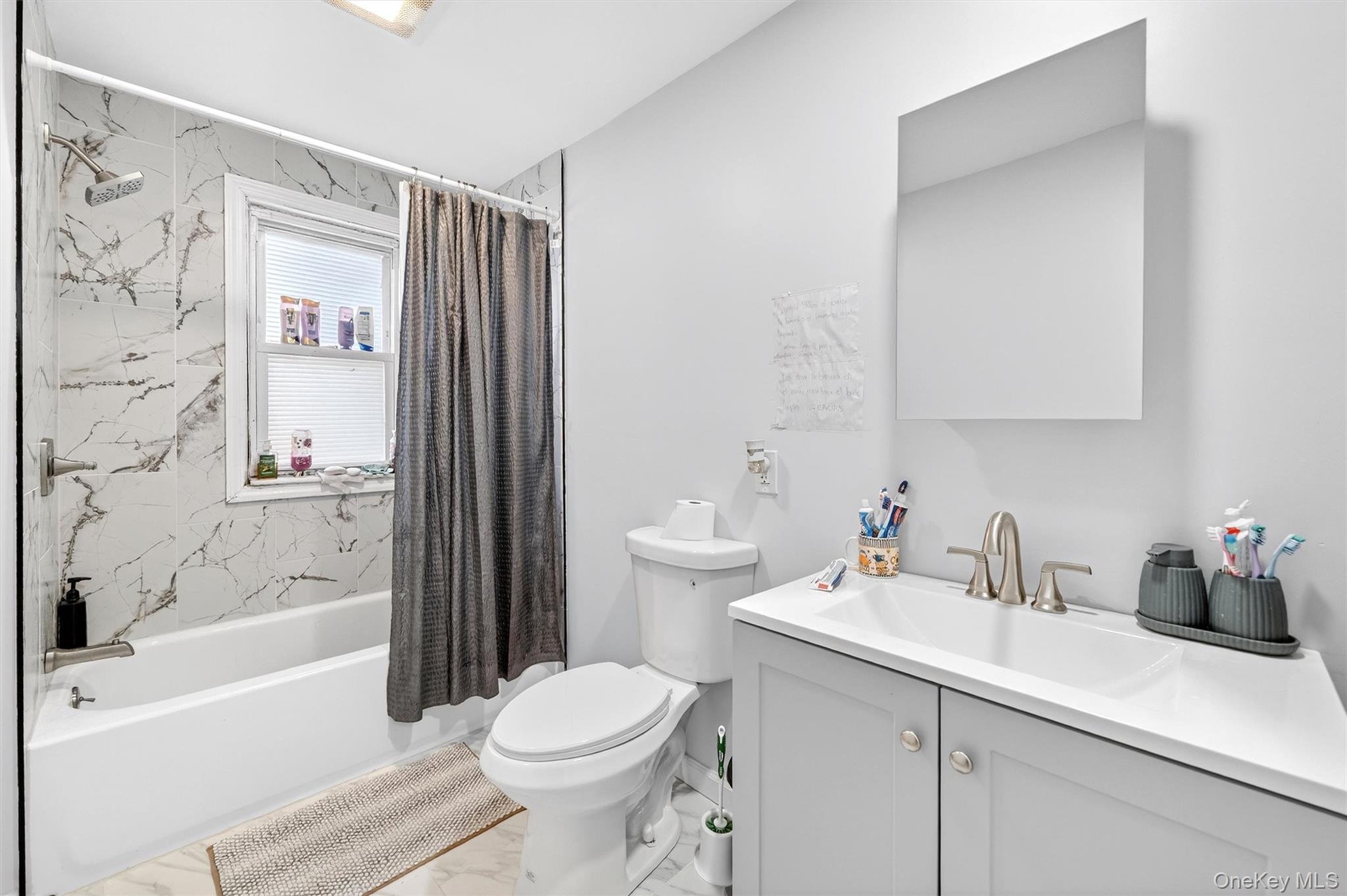 1106 Orchard Street Peekskill, NY 10566 - Photo 24 of 32 Full bathroom featuring shower / bathtub combination with curtain, vanity, and light marble finish floors