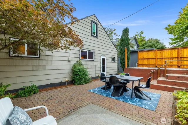 a view of a patio with table and chairs with wooden floor and fence