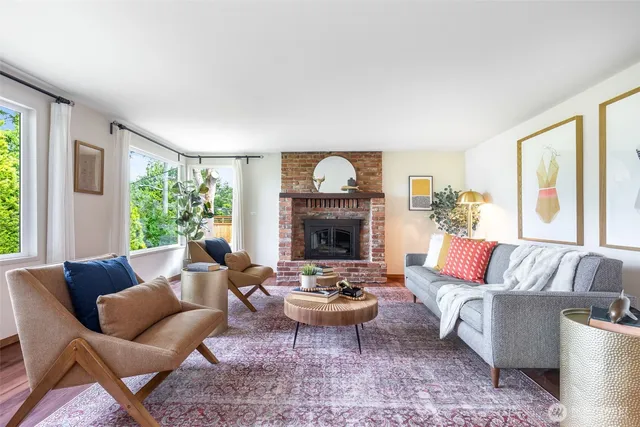 a living room with furniture fireplace and a large window