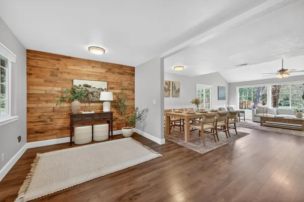 a living room with couches and kitchen view with wooden floor