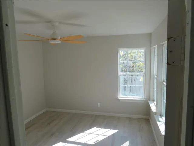 an empty room with windows and cabinet