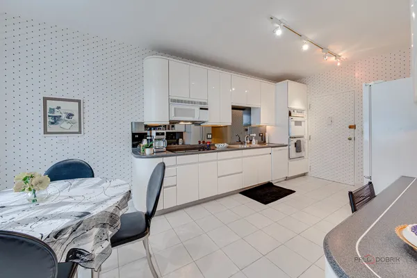 a kitchen with a sink a stove a refrigerator cabinets and dining table