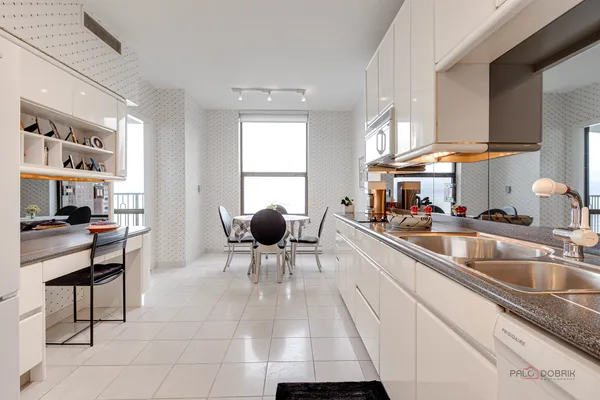 a kitchen with stainless steel appliances kitchen island granite countertop a sink and a refrigerator