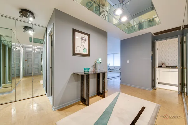 a living room with stainless steel appliances furniture a rug and a view of kitchen