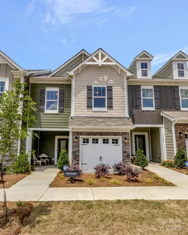 a front view of a house with yard and parking