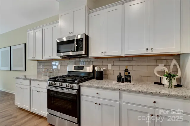 a kitchen with white cabinets and appliances