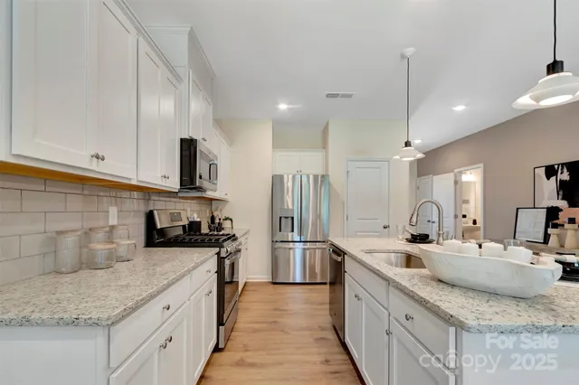 a kitchen with stainless steel appliances granite countertop a sink stove and refrigerator