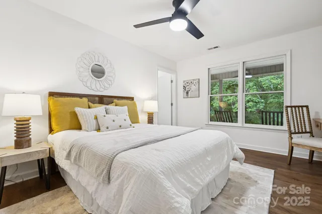 a bedroom with a bed a chair and a large window