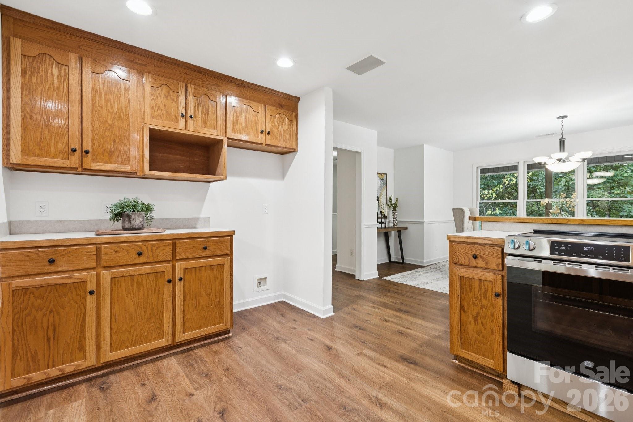 3090 Goblet Road Richburg, SC 29729 - Photo 19 of 48 a kitchen with stainless steel appliances granite countertop a refrigerator a stove top oven a sink dishwasher and white cabinets with wooden floor