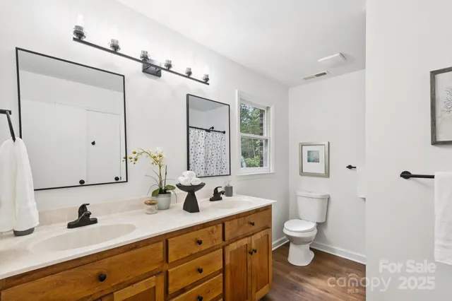 a bathroom with a granite countertop sink a toilet and a mirror