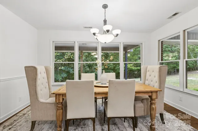 a view of a dining room with furniture large windows and wooden floor