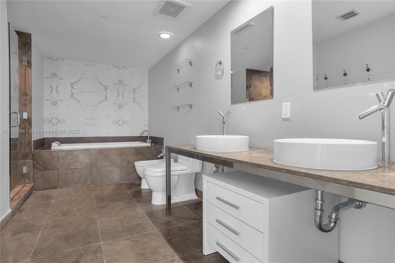 465 Brickell Avenue, Unit 5002 Miami, FL 33131 - Photo 20 of 26 a bathroom with a sink a toilet and mirror