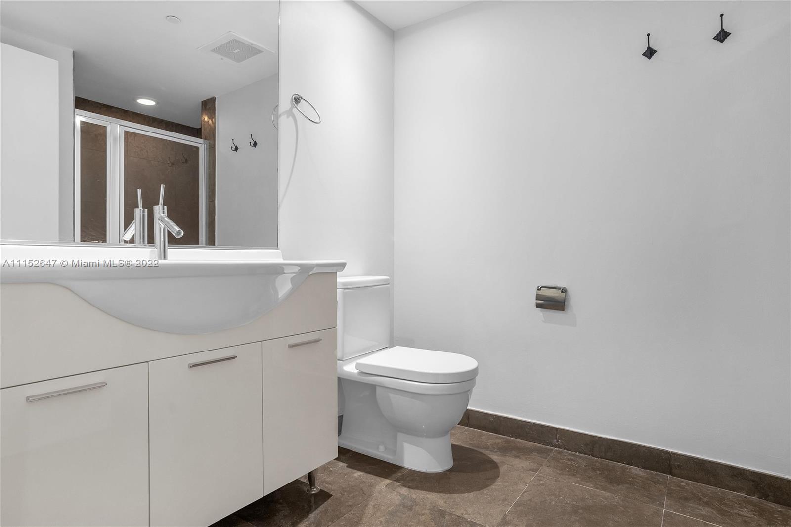 465 Brickell Avenue, Unit 5002 Miami, FL 33131 - Photo 25 of 26 a bathroom with a toilet sink and mirror