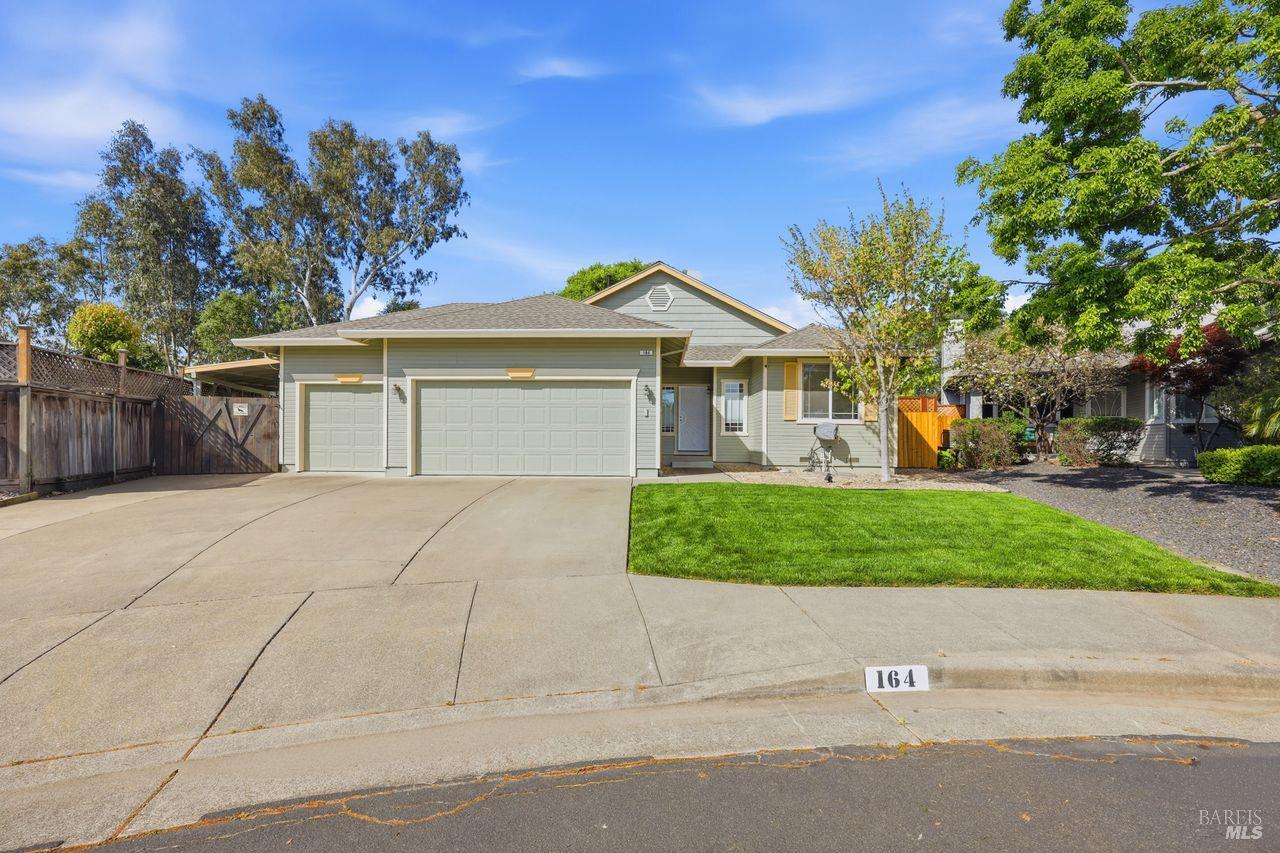 a front view of a house with a yard and trees