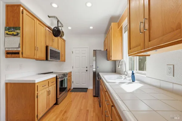 a kitchen with stainless steel appliances granite countertop a sink stove and wooden cabinets