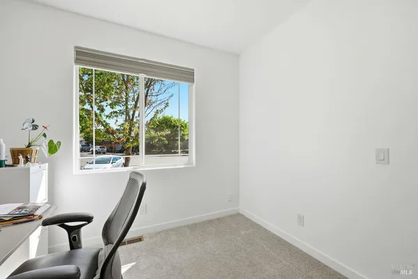 a view of a workspace with furniture and a window