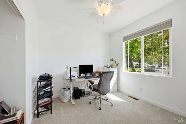 a view of a workspace with furniture and clutter