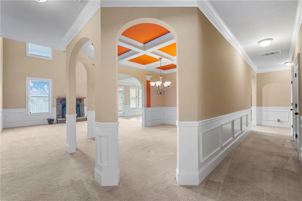 12 Juno Street Fort Mitchell, AL 36856 - Photo 4 of 43 Hallway featuring arched walkways, coffered ceiling, healthy amount of natural light, crown molding, and light colored carpet