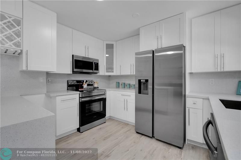 22341 Sea Bass Drive Boca Raton, FL 33428 - Photo 19 of 52 a kitchen with a refrigerator stove and white cabinets
