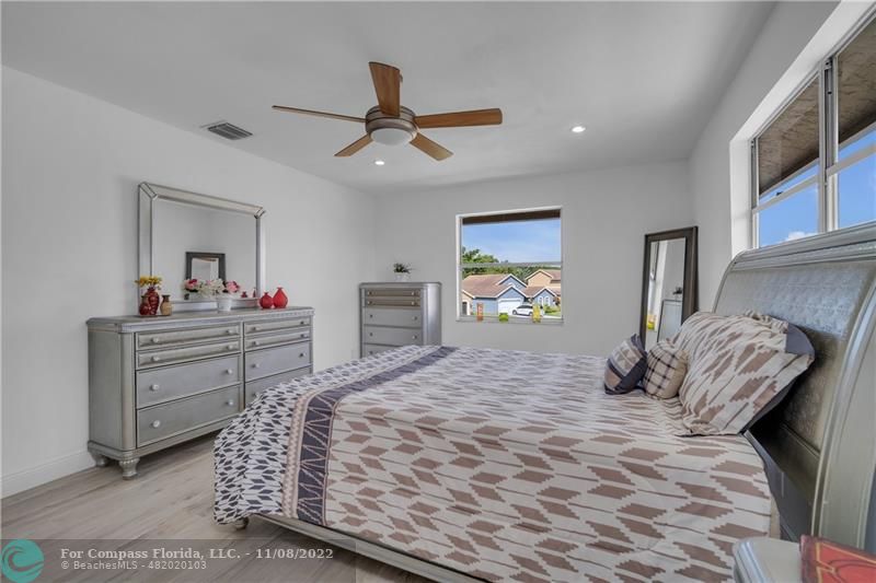 22341 Sea Bass Drive Boca Raton, FL 33428 - Photo 23 of 52 a bedroom with a bed and a chandelier