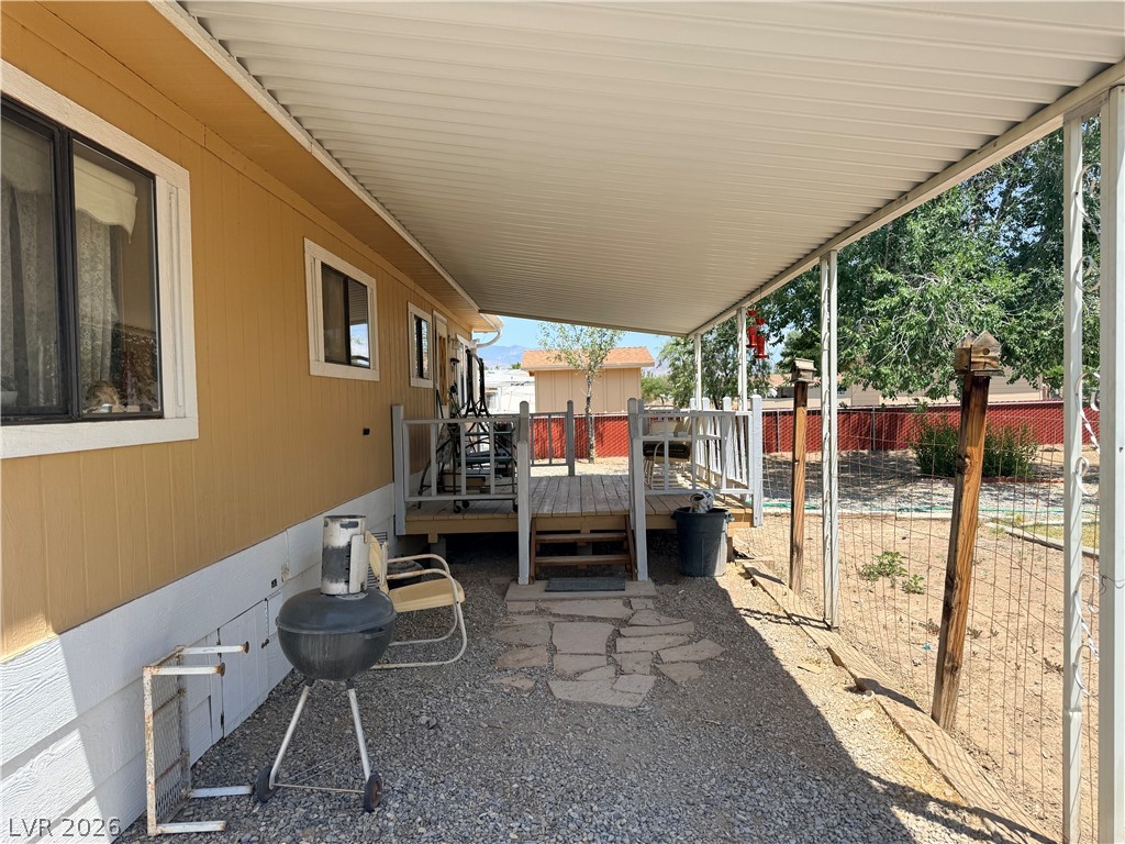 1391 West Dyer Road Pahrump, NV 89048 - Photo 22 of 50 An inviting covered patio adjoins a raised deck, perfect for outdoor dining and relaxation.
