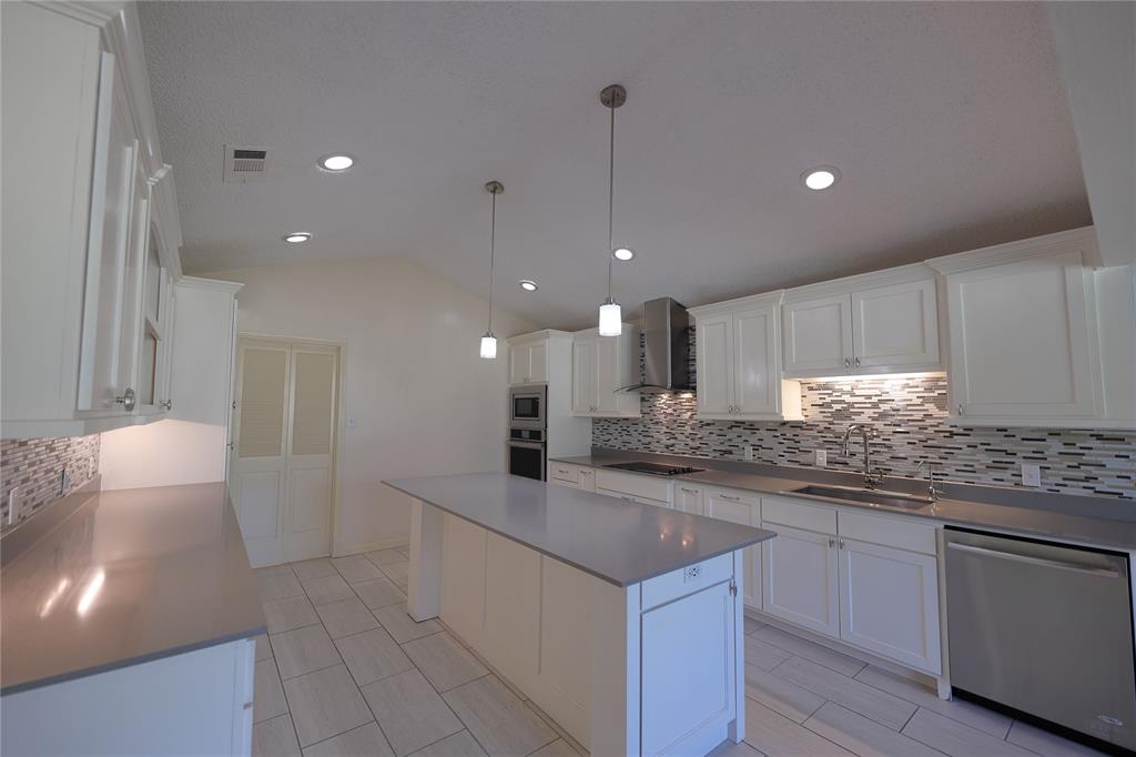 907 Red Oak Creek Road Ovilla, TX 75154 - Photo 6 of 20 Kitchen featuring white cabinetry, a central island, stainless steel appliances, recessed lighting, and a mosaic tile backsplash