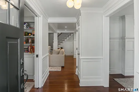 a kitchen with a stove a refrigerator and a dining table with wooden floor