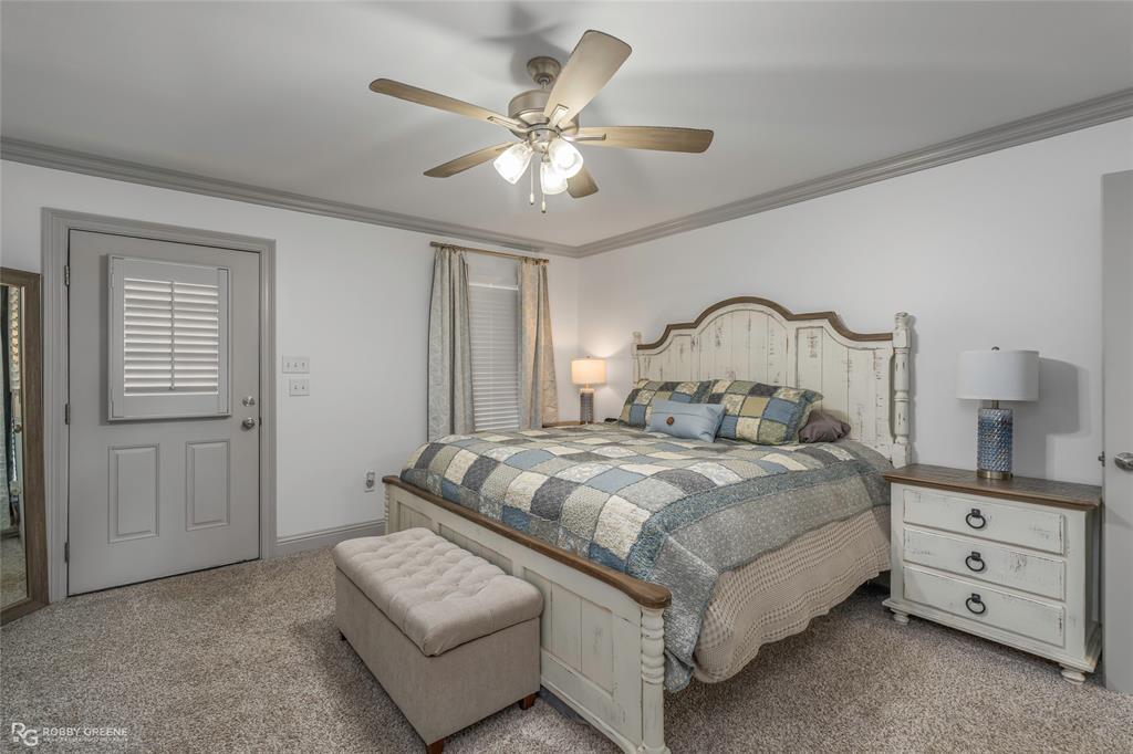 396 Collinswood Road Stonewall, LA 71078 - Photo 26 of 32 a bedroom with a bed and a chandelier