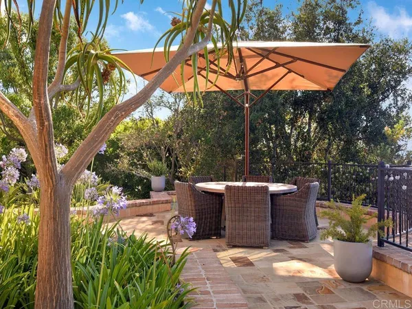 a view of a patio with couches table and chairs and potted plants