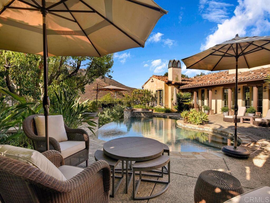 4272 Via Ravello Rancho Santa Fe, CA 92091 - Photo 20 of 58 a view of a patio with couches table and chairs under an umbrella