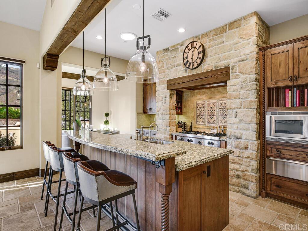 4272 Via Ravello Rancho Santa Fe, CA 92091 - Photo 24 of 58 a kitchen with a table chairs stove and cabinets