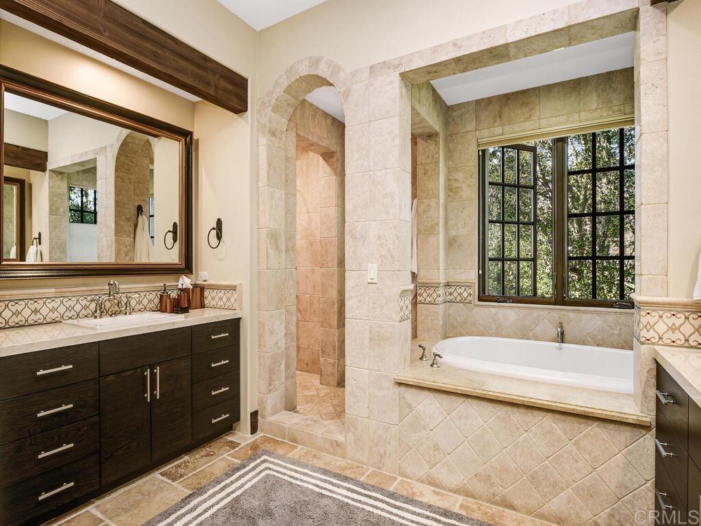 4272 Via Ravello Rancho Santa Fe, CA 92091 - Photo 33 of 58 a spacious bathroom with a tub sink and mirror