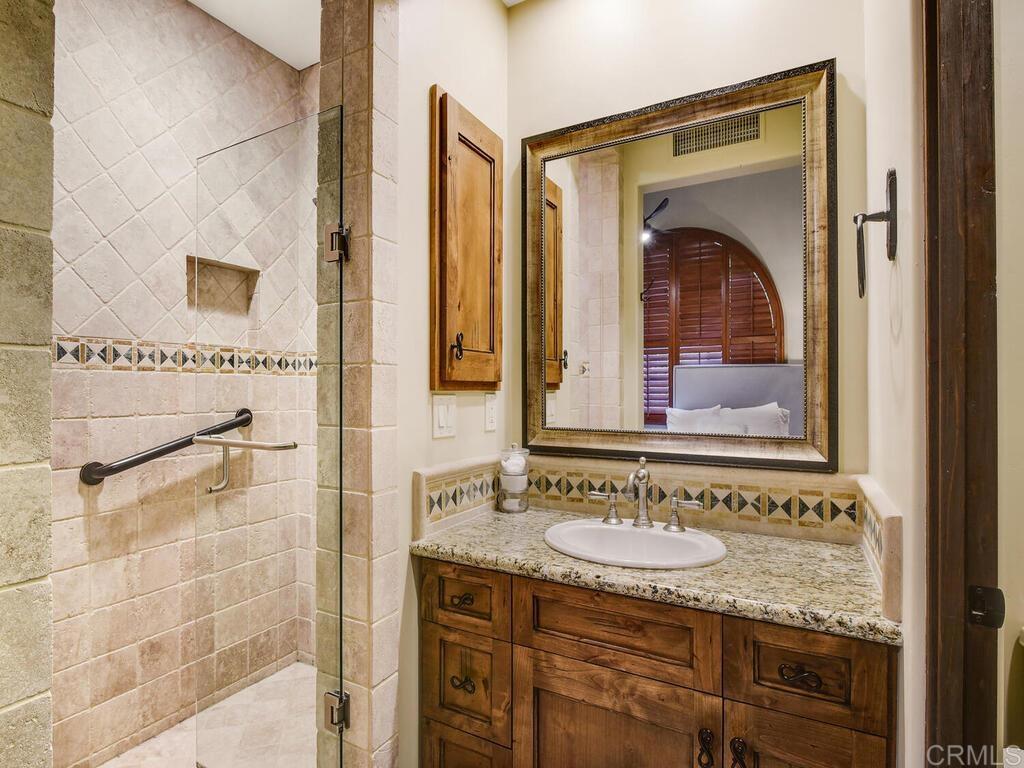 4272 Via Ravello Rancho Santa Fe, CA 92091 - Photo 41 of 58 a bathroom with a granite countertop sink and a mirror