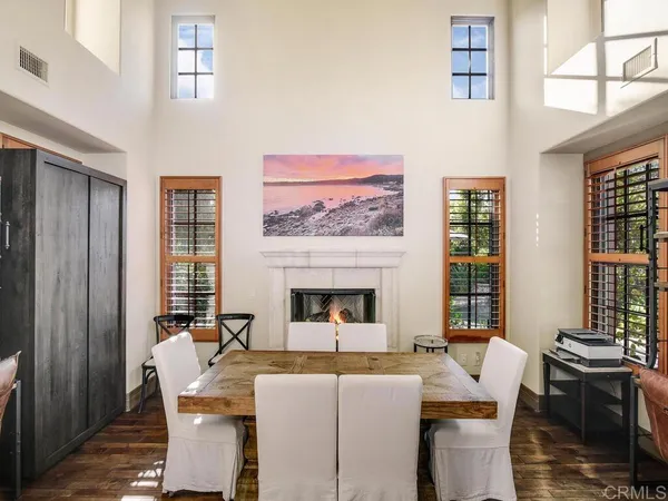 a living room with furniture a fireplace and large windows