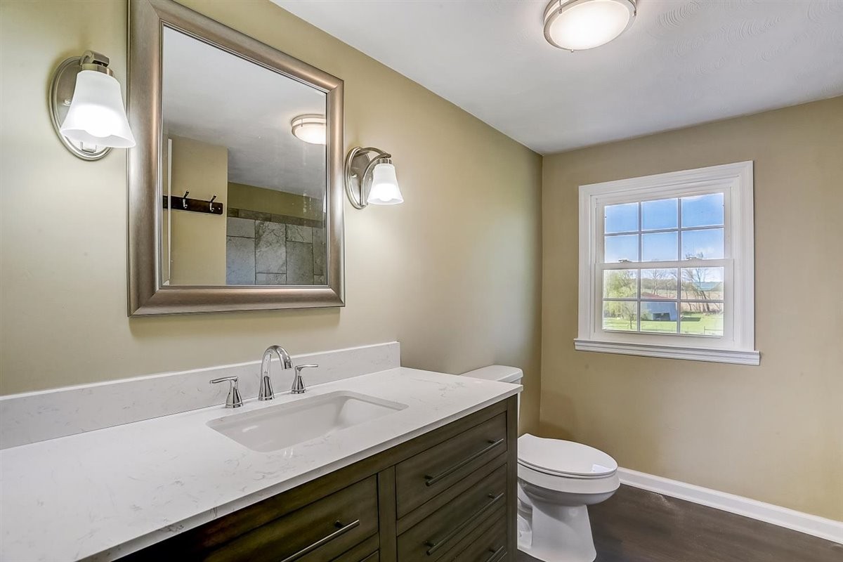 555 White Road Portland, TN 37148 - Photo 19 of 30 a bathroom with a granite countertop sink mirror vanity and a toilet