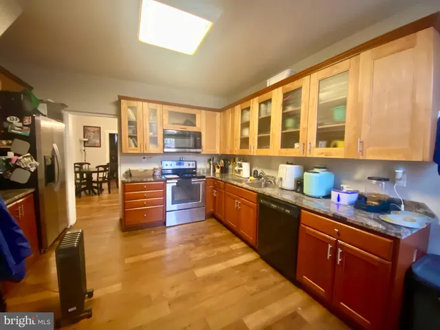 a large kitchen with stainless steel appliances granite countertop a stove and large cabinets