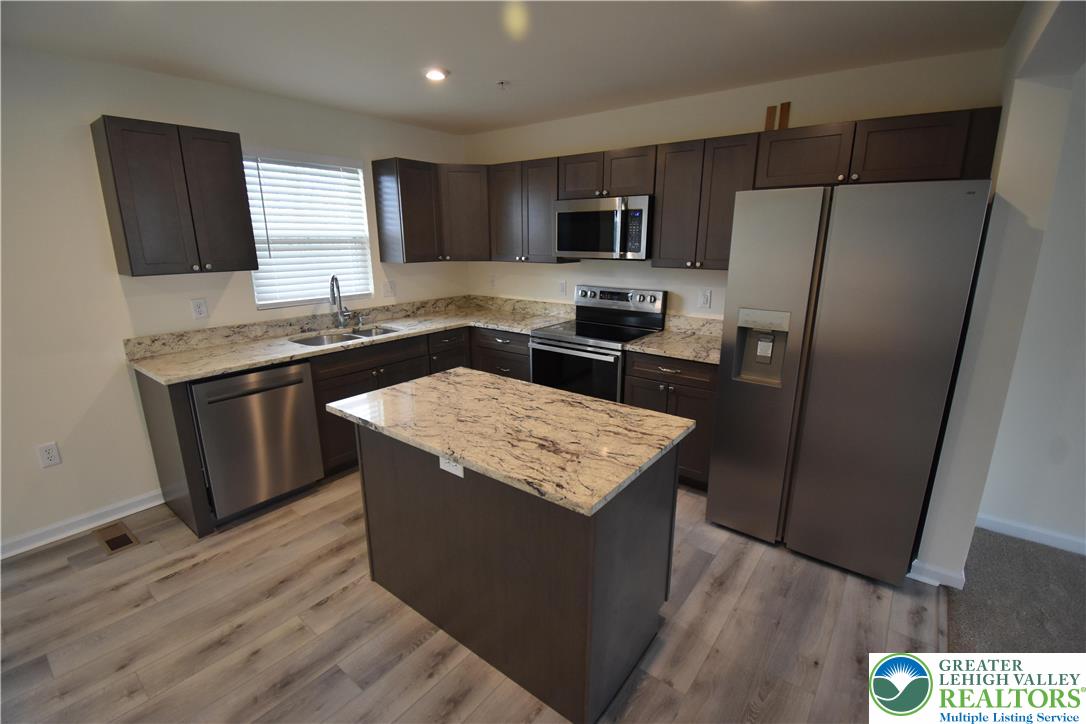 1924 Alex Road Easton, PA 18040 - Photo 3 of 22 a kitchen with stainless steel appliances granite countertop a stove top oven a refrigerator a sink and dishwasher with wooden floor