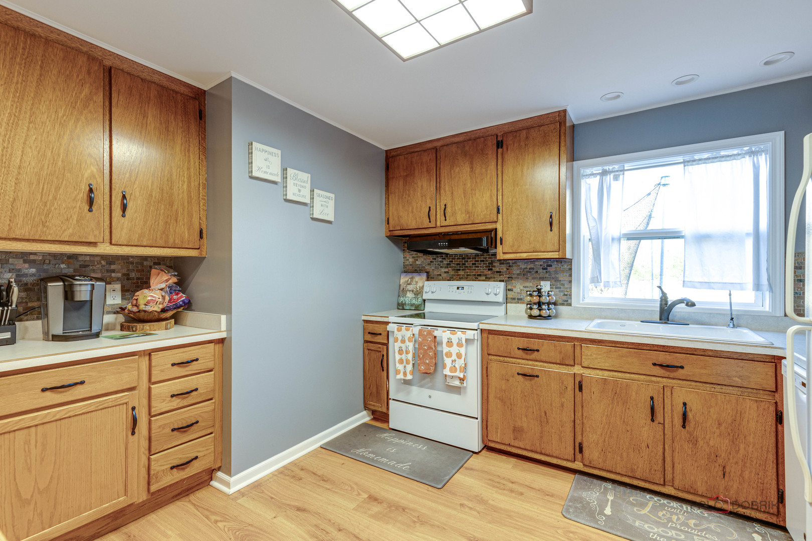 612 Kent Road McHenry, IL 60051 - Photo 6 of 18 a kitchen with cabinets wooden floor and black stainless steel appliances