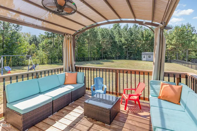 a balcony with wooden floor and outdoor seating