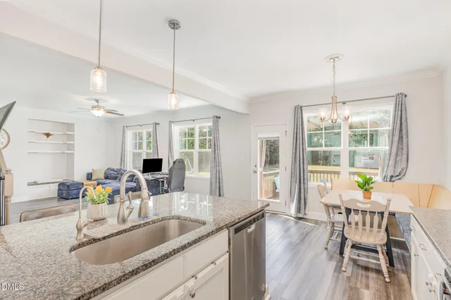 a kitchen with granite countertop a sink dining table and chairs