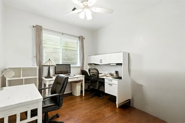 a view of a workspace with furniture and a window