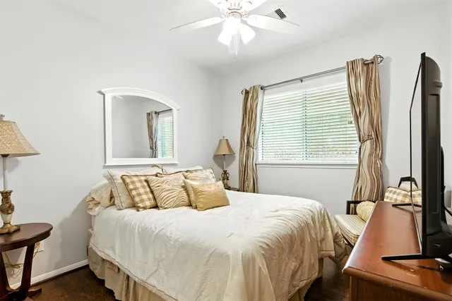 a bedroom with a bed and a flat tv screen on dresser