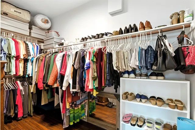 a view of walk in closet with clothes and shoes