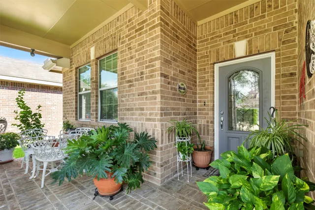 a view of a entryway door of the house with potted plants